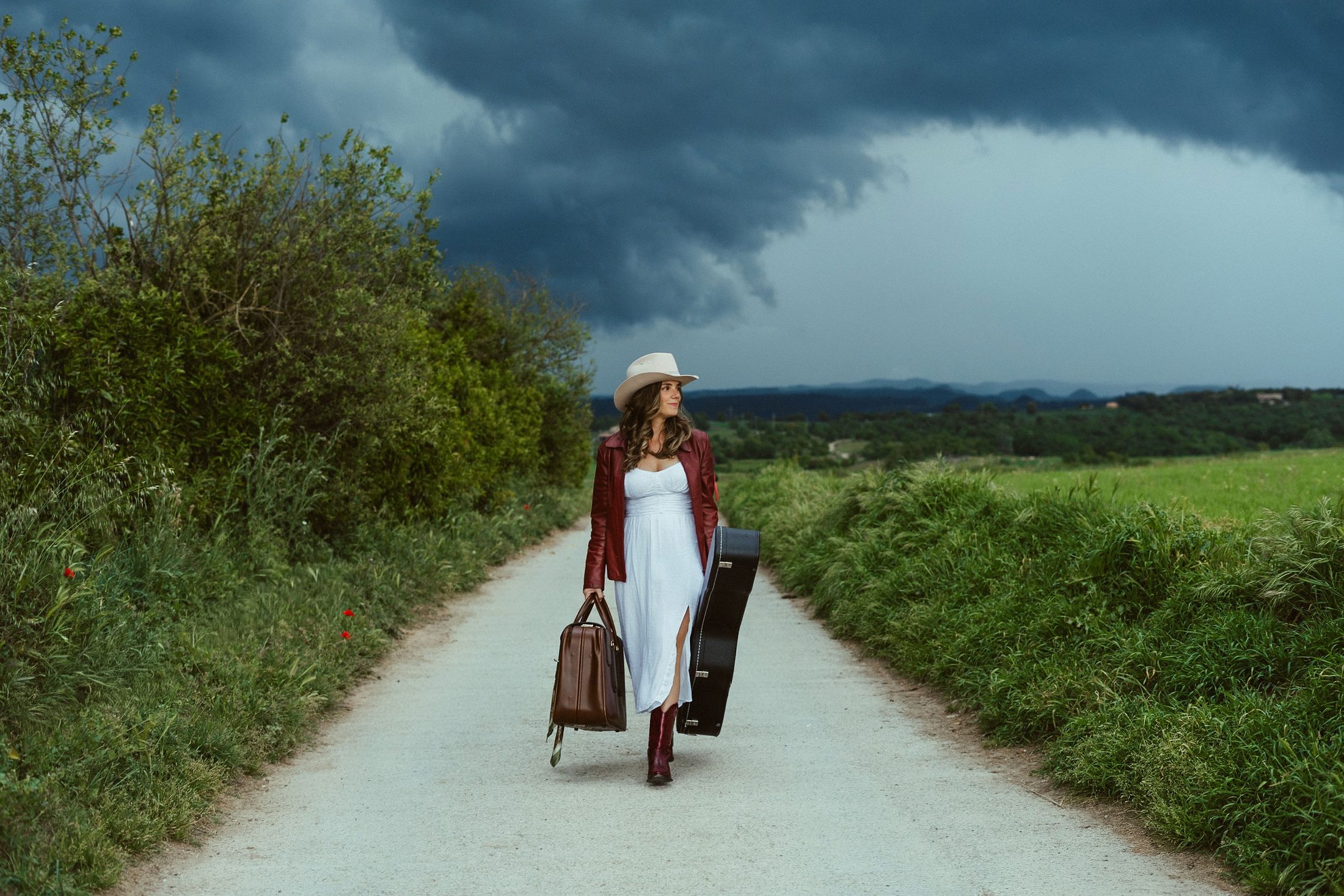 Bruna Anfruns caminant per un camí d'Osona amb la guitarra